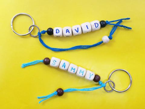 Keychains made from thread and letter beads.