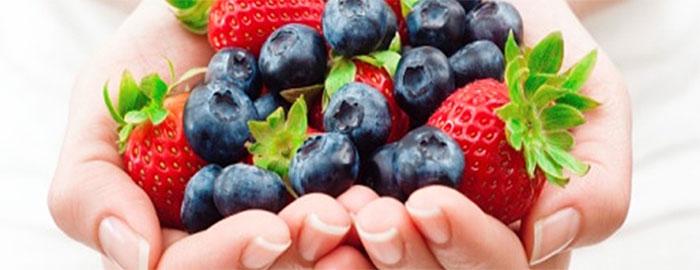 Cupped hands holding strawberries and blueberries