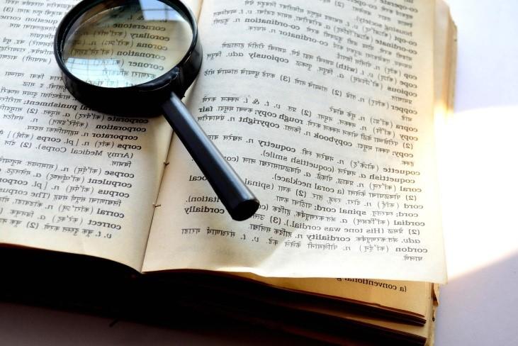 a magnifying glass rests on an open book