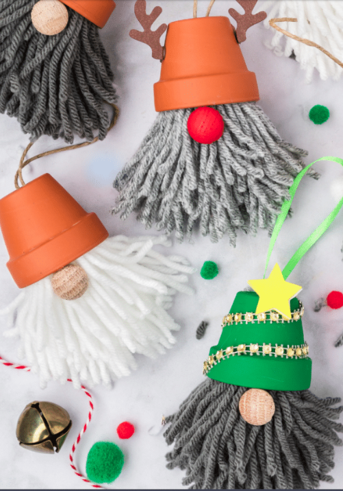 Three small crafted gnomes with hats, noses, and beards, on a decorated white background. 